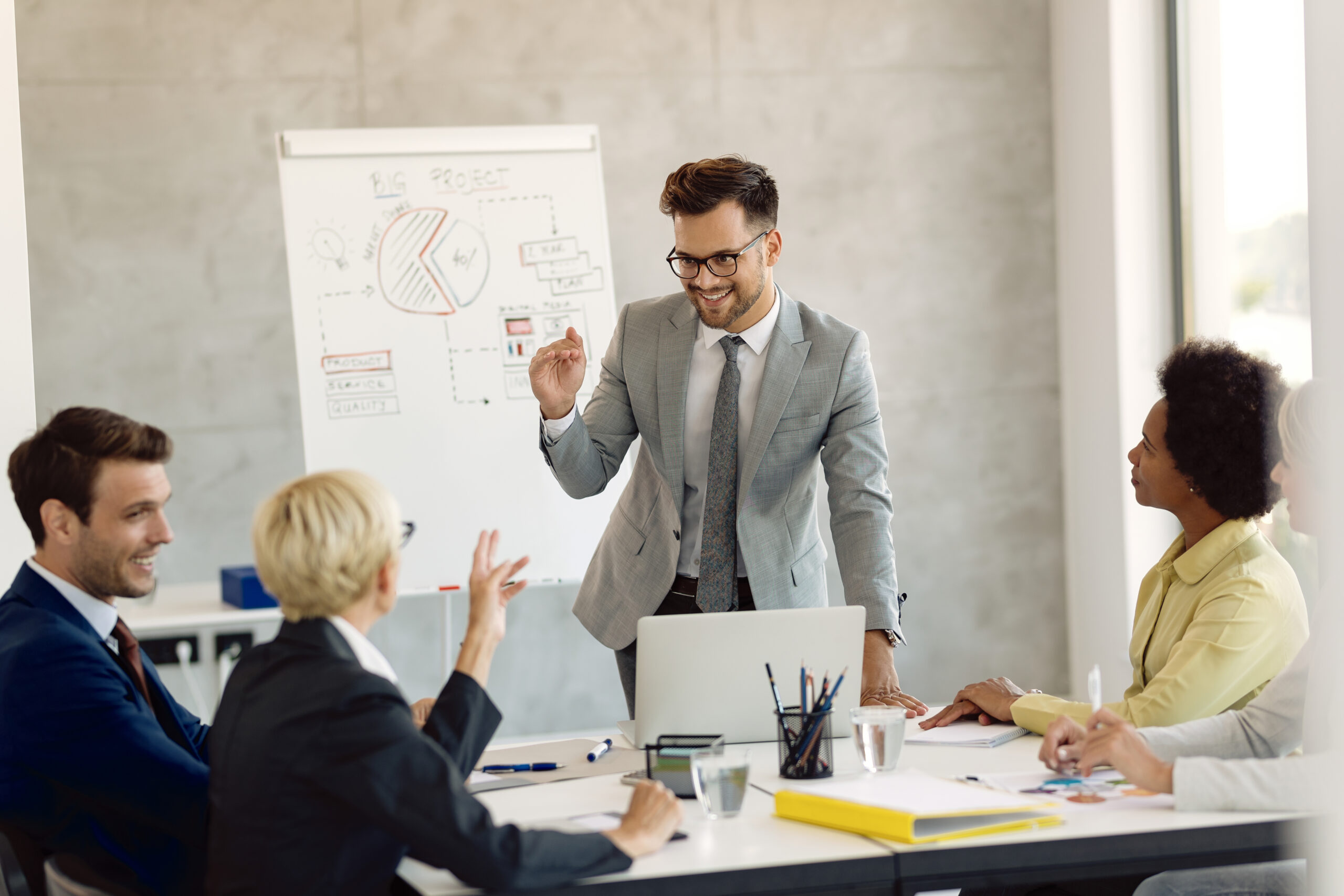Young businessman communicating with his colleagues during a mee